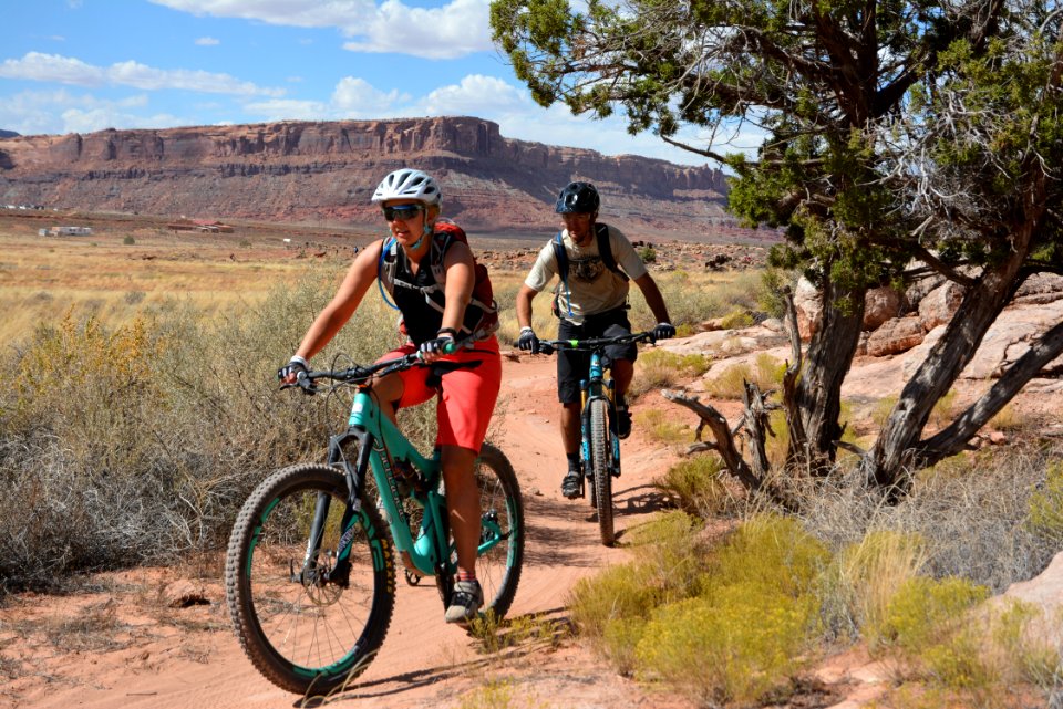A woman and a man bike on the Bar M Trails