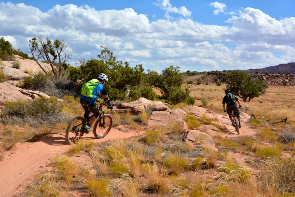 Two riders bike between boulders on the Bar M Trails