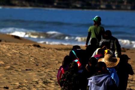 Second graders from Santa Rita Elementary School follow in the footsteps of Return of the Native program coordinator Marina Maze as she leads them to the planting site at Monterey State Beach.