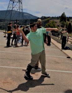 A student demonstrates how to throw an atlatl at BLM's Archaeology station. Flaming Gorge Dam, UT. Photo by BLM Utah