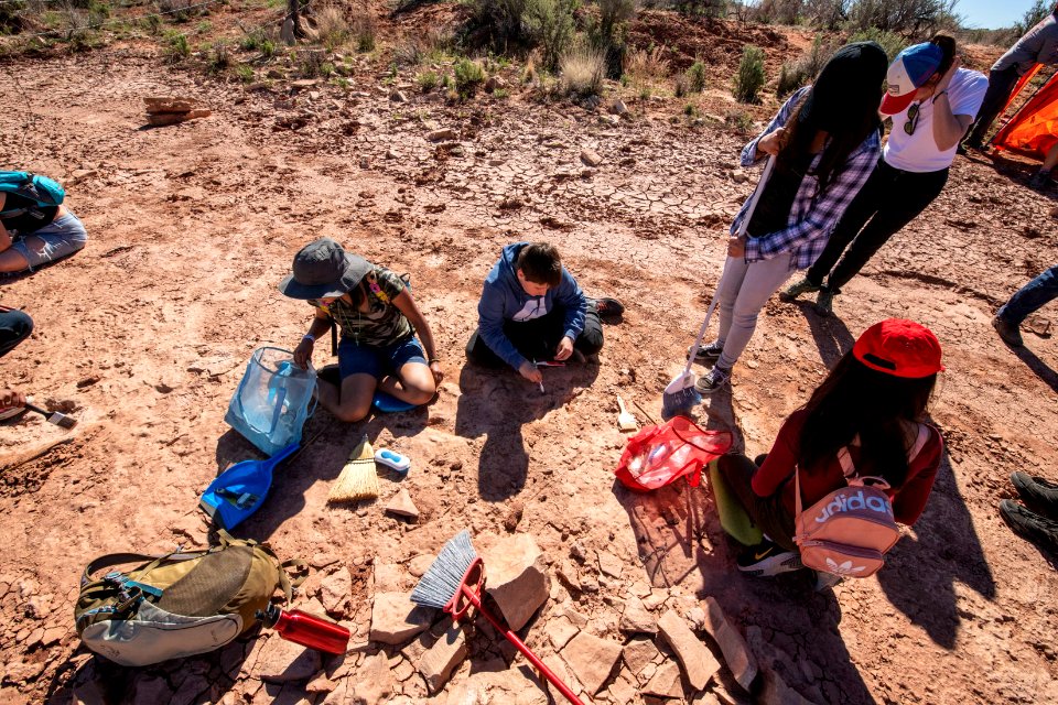 Cleaning Dino tracks at a track site near Moab, UT. Photo by Eric Delphenich