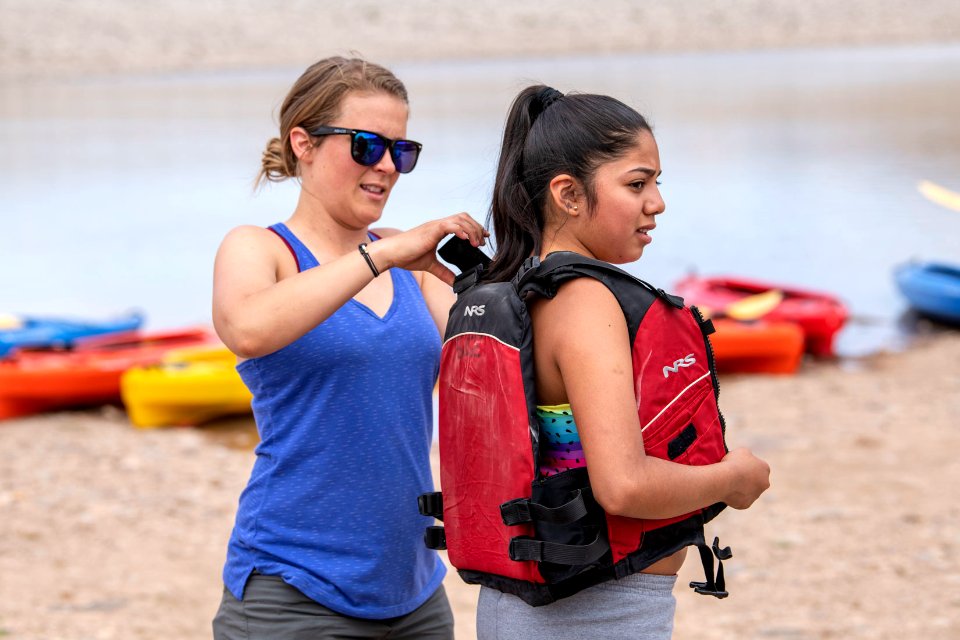 Safety first! BLM intern Whitney May assists a student with her lifejacket at Ken's Lake, near Moab, UT. Photo by Eric Delphenich