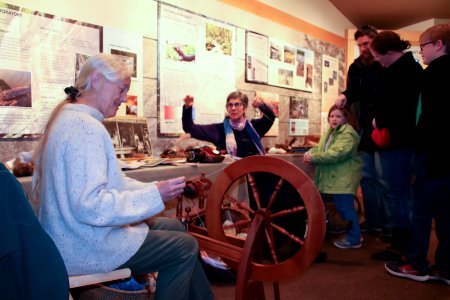 Volunteers demonstrate spinning wheel, December 2017--Warren Bielenberg