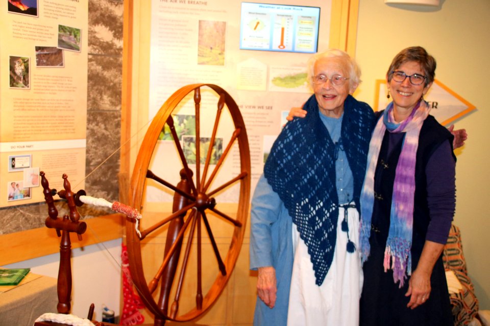 Volunteers pose next to spinning wheel, December 2017--Warren Bielenberg