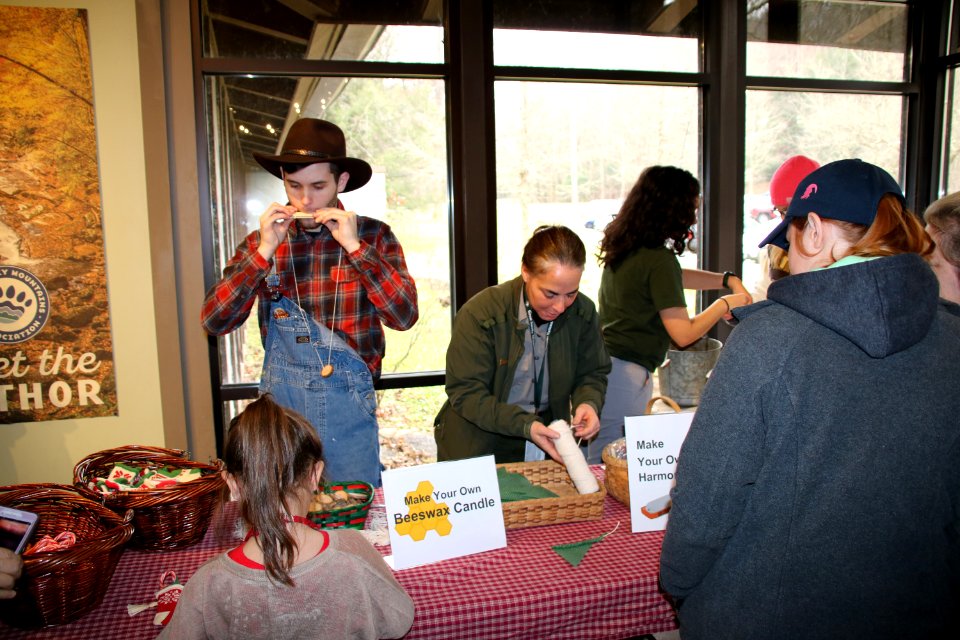Intern Zack Curtis, Ranger Katie Corrigan, and intern Dominique Sanchez assist visitors with crafts at the 2018 Festival of Christmas Past, December 8, 2018--Warren Bielenberg