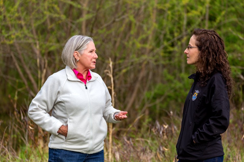 Marilyn Spong walks with Megan Lang (USFWS) around the restored wetland