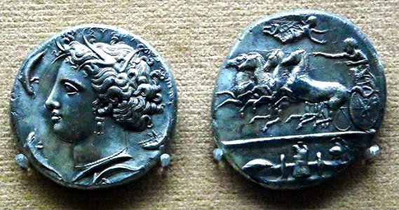 Coin of Syracuse (Dionysius I: 405-367 BC) - Head of the Nymph Arethusa between the dolphins; Quadriga and weapons - Naples, Archaeological Museum