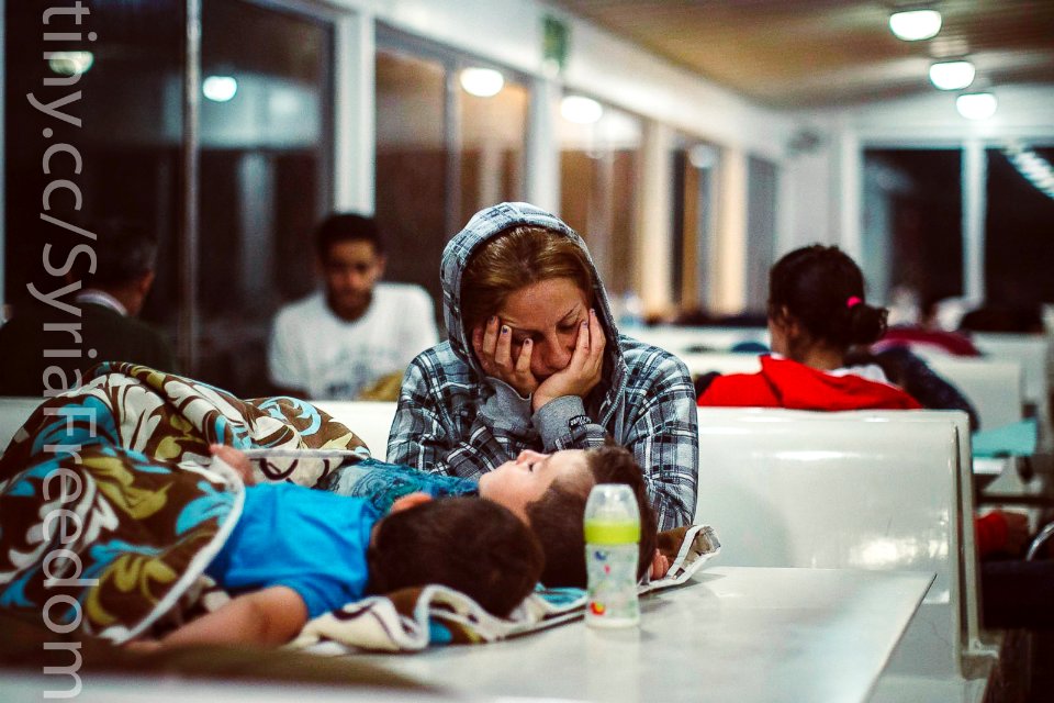 A refugee sleeps with her children on a ferry traveling from the northeastern Greek island of Lesbos to the Athens port of Piraeus, Sept. 9, 2015.