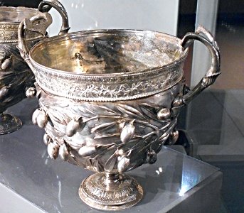 Goblet with olive branches, handles with rosettes and lotus fowers. Under the base the words AUREL[IUS] AUGUR[INUS] - late 1st century BC - embossed silver - Exhibition "Myth and Nature" at Archaeological Museum of Naples, until September 30, 2016 photo