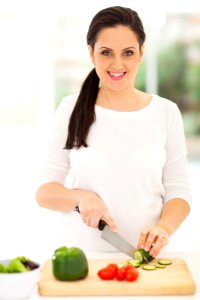 portrait of pregnant woman cutting vegetables photo