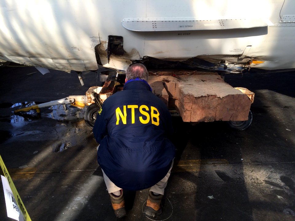 NTSB Investigator-in-Charge Dan Bower documenting damaged section of Delta flight 1086 that skidded of the runway at LaGuardia Airport.