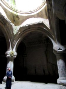 13th century burial vault this priest was singing. Hole in the floor looks onto the church below allowing the burial chamber connection to the church Geghard Monastery Armenia photo