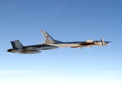 A CF-18 "Hornet" from 4 Wing Cold Lake flies next to a Russian Tu-95 "Bear" bomber.