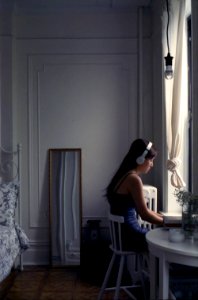 Girl listening to music by window