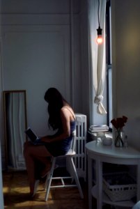 Girl using laptop by window