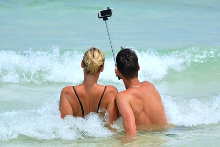 Woman selfiestick ocean photo