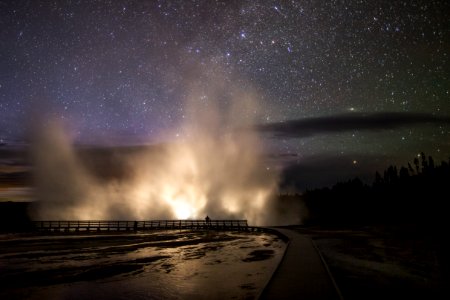 Car headlights illuminate the steam plume from Excelsior Geyser in the Midway Geyser Basin photo