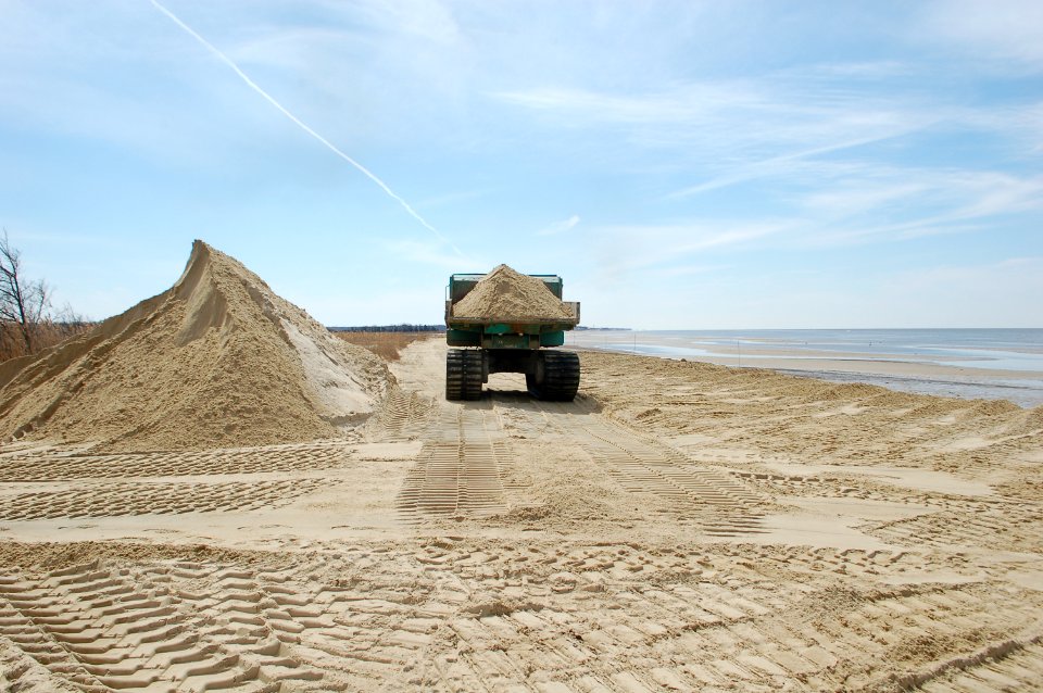 Rubber-tracked dump truck hauls sand at Kimbles Beach.