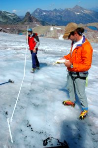 Scientists using ablation sticks to measure the retreat of Sperry Glacier