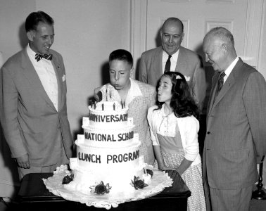 Pres Eisenhower receiving cake 10th Anniversary School 