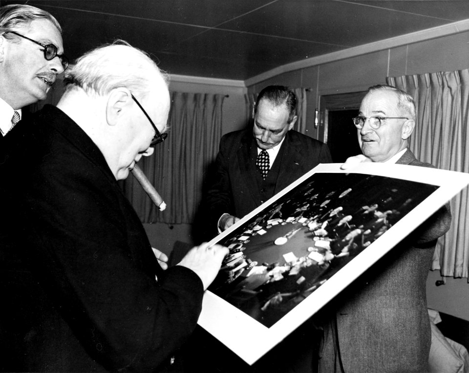 Harry S. Truman giving Winston Churchill photograph of Potsdam Conference, as Anthony Eden and Dean Acheson look on, during a meeting aboard U. S. S. Williamsburg, January 5, 1952