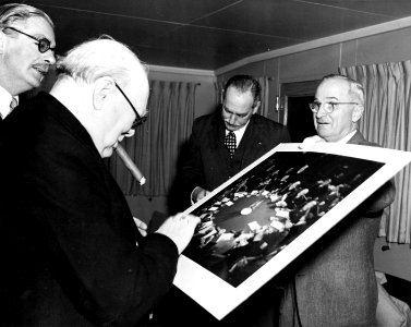 Harry S. Truman giving Winston Churchill photograph of Potsdam Conference, as Anthony Eden and Dean Acheson look on, during a meeting aboard U. S. S. Williamsburg, January 5, 1952