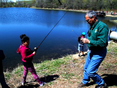 Regional Director Tom Melius Helps a Student with Fishing Bait photo