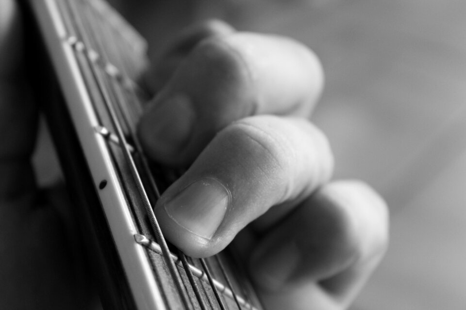 Black and white fingers playing guitar