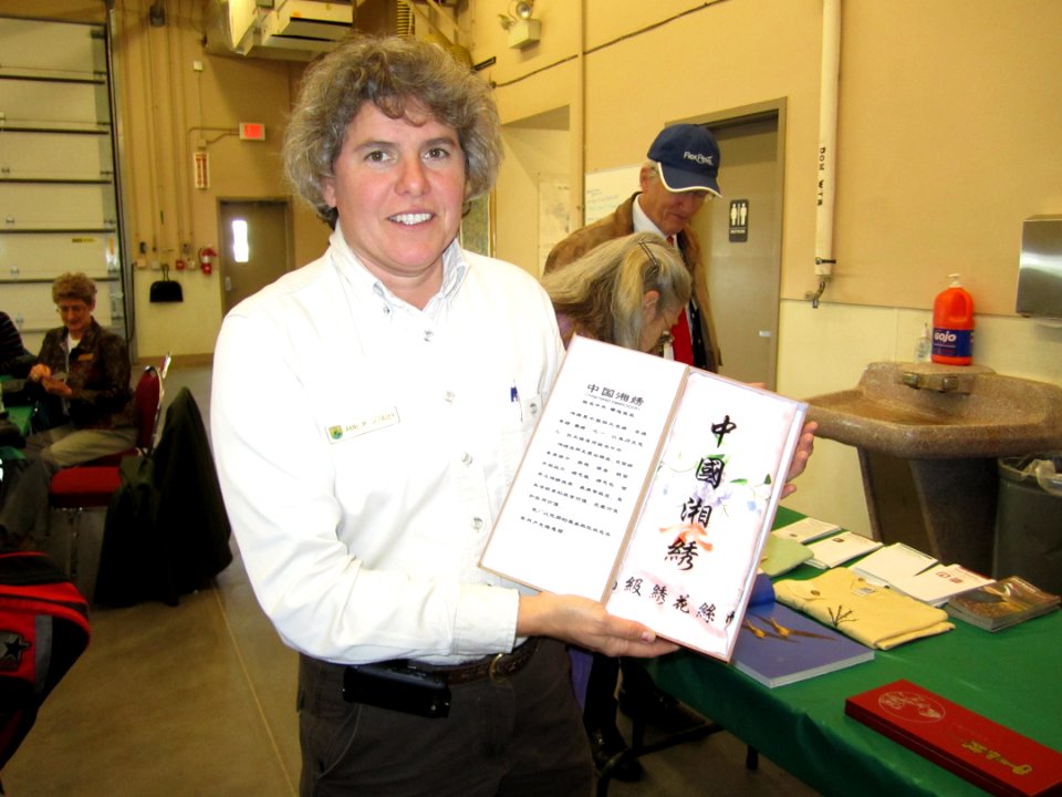 Refuge Manager Anne Sittauer displays the painted silk that was a special gift from the delegation