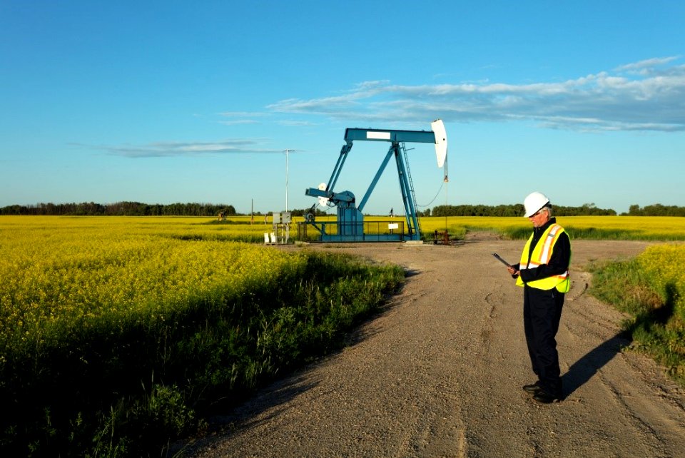 A man in front of an oil pump