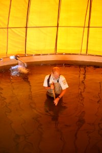 USFWS biologist cleans circular fish rearing pool of sediment photo