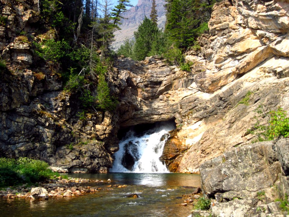 Running Eagle Falls - [Two Medicine Area] - 4 (Early in the season when there is more water flowing, it cascades from both over the top of the cliff and also from the middle of the rock face visible in this photo.)