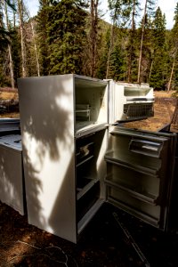 Old Refrigerator Sitting Outside with its Doors Open