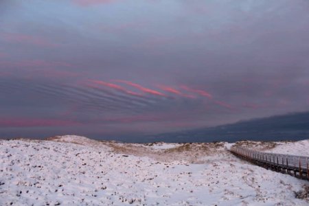 Snow Covered Dunes under pink and grey skies photo