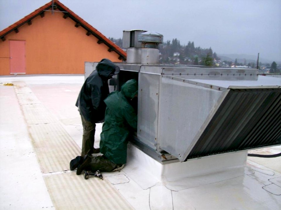 Working on the broken heating unit in the rain