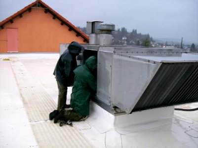 Working on the broken heating unit in the rain