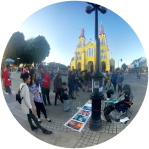 Artista callejero con spray aerosol frente a iglesia.