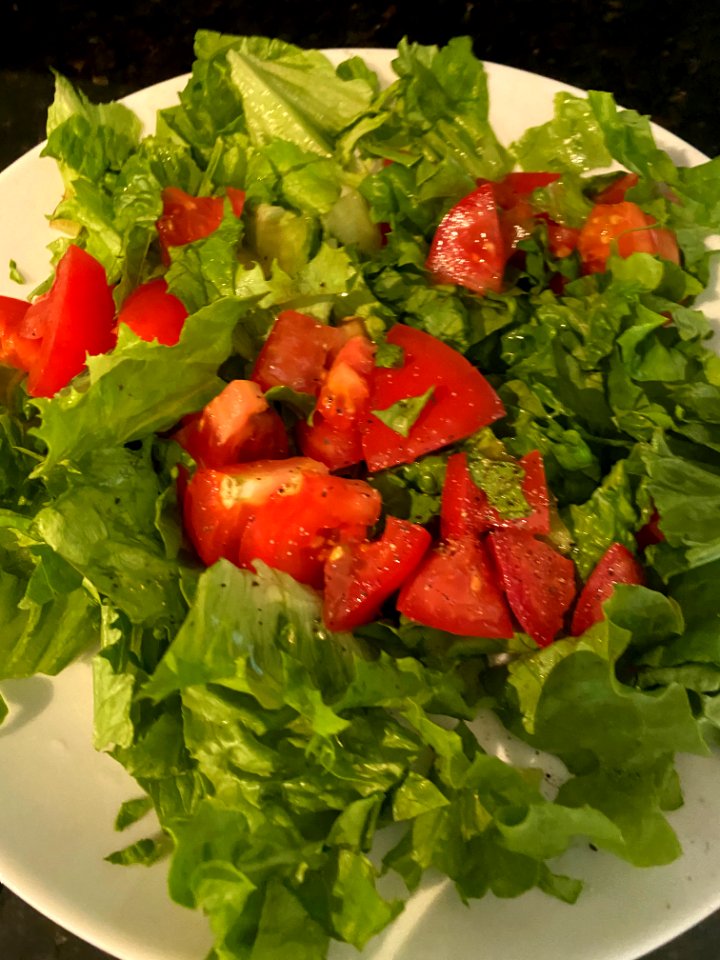 Breakfast: Salad with lettuce and tomato on the vine. Dressed with olive oil and black pepper.