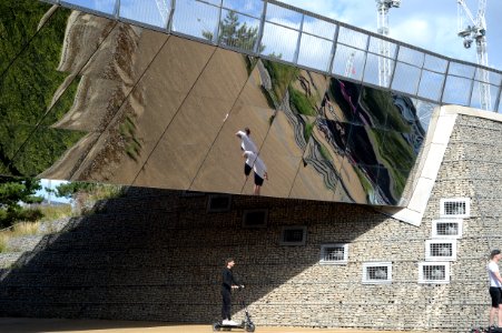 Polished stainless steel bridge reflecting the ground below