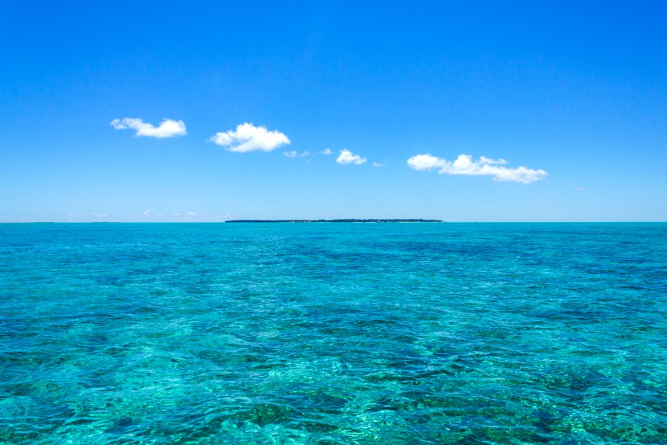 A thin strip of clouds hangs over Midway Atoll National Wildlife Refuge