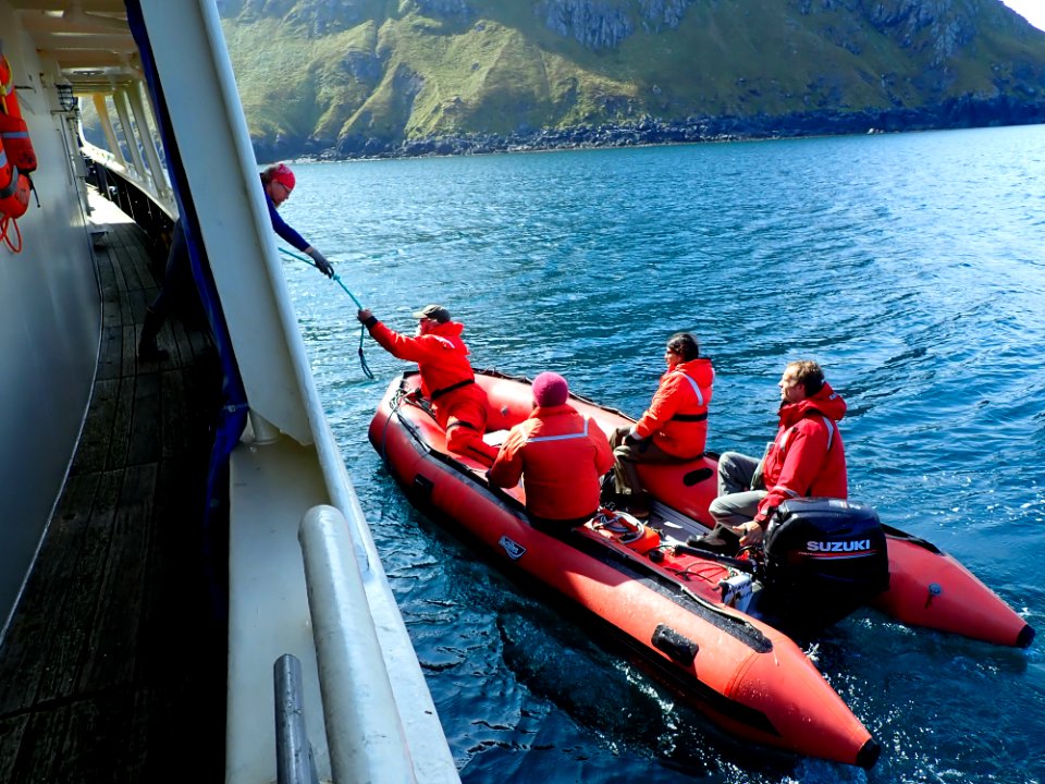 A skiff with people gets ready to go ashore