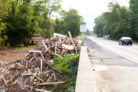 Debris piled high next to a concrete bridge a month after the flooding that occurred in WV. A section of wooden bridge that collapsed during the flooding can also be seen.