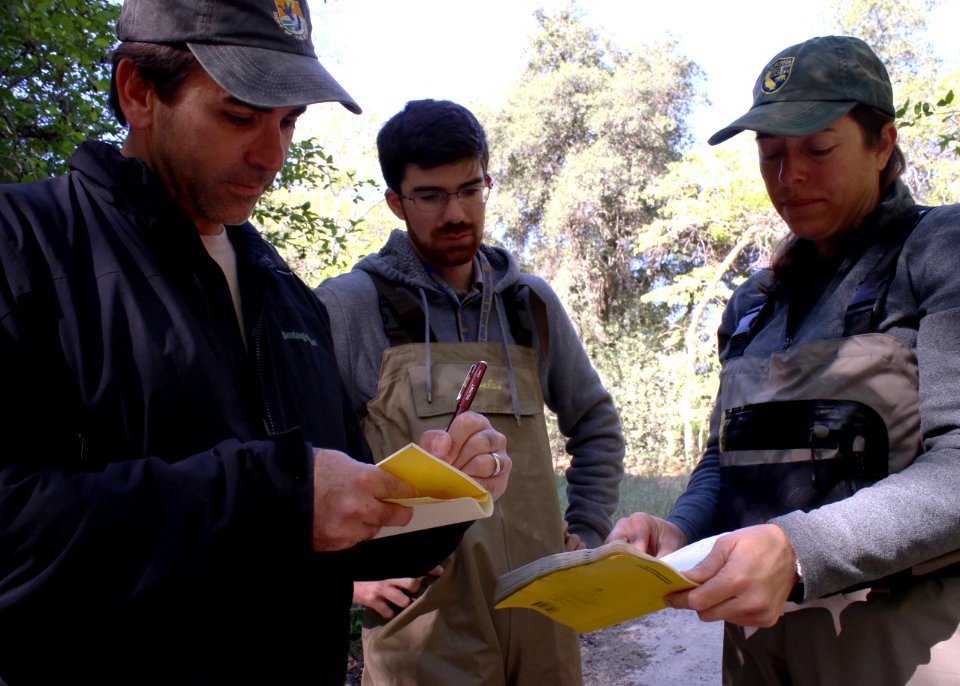 Eric Morrissette (l), a senior fish and wildlife biologist with the USFWS, takes notes on water quality from Jennifer Pareti, an environmental scientist with the CDFW, as Abram Tucker, a scientific aid with the CDFW watches.