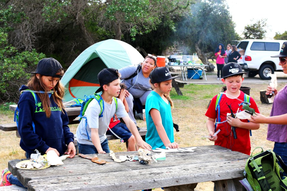 Bryanna Vaughn (right) discusses the harmful effects of plastics to wildlife, oceans, and to people. Minimizing their impact to campsite, the kids properly store food away from wildlife, recycle, and use biodegradable products.
