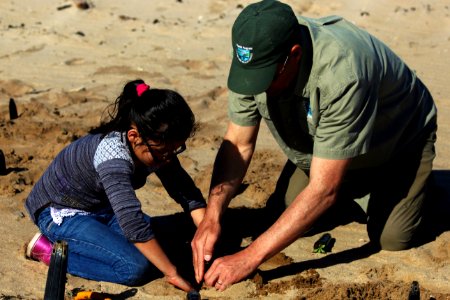 Fish and wildlife biologist Shawn Milar lends a helping hand to a second grader from Santa Rita Elementary School.