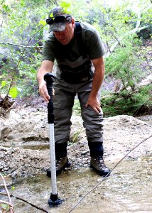 Tim Hovey, a senior environmental scientist, specialist, with the California Department of Fish and Wildlife (CDFW) tests water velocity of a creek to confirm viability for unarmored threespine sticklebacks, a federally and state endangered species. photo