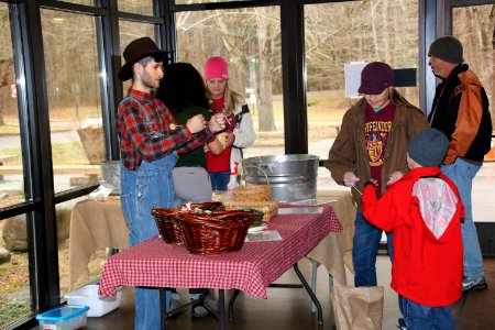 Intern Zack Curtis teaches visitors how to make buzz buttons at the 2018 Festival of Christmas Past, December 8, 2018--Warren Bielenberg