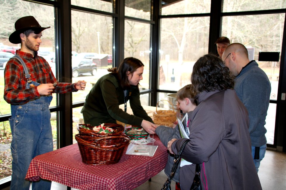 Intern Zack Curtis and Ranger Maggie Blake assist visitors with crafts at the 2018 Festival of Christmas Past, December 8, 2018--Warren Bielenberg