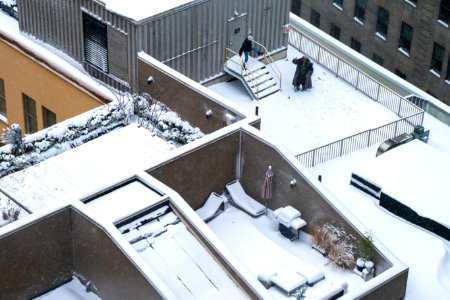 A couple plays in the snow on the rooftop of 53 Wall photo