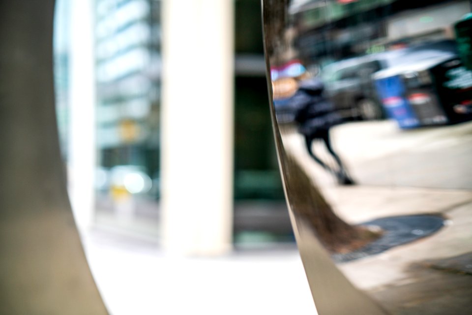 Reflection of woman in sculpture n Wall Street